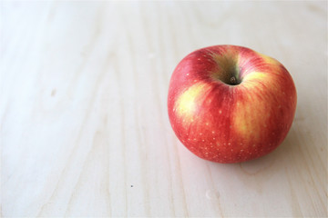 Isolated fresh whole red boskoop red apple fruit on wood table
