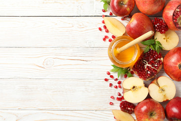Apple, pomegranate and honey on wooden background, top view