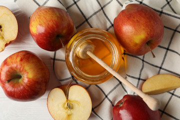 Apples and honey on wooden background, top view