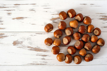 Hazelnuts on a white wooden background. a stack of nuts. Hazelnuts background, healthy Food, top view, layout