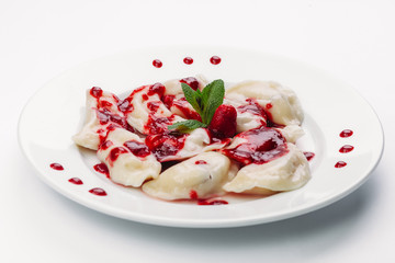 dumplings with red sauce on a white plate