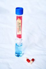 Flasks with red and blue liquid and KOVID-19 coronavirus on a white background