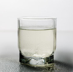 Muddy water in a glass on the table on a white background.