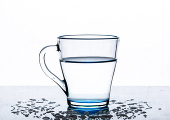 Clear, transparent water in a glass Cup on a table on a white background.