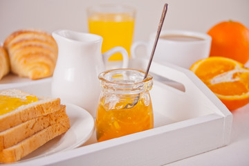 Bread toast with orange jam, glasses of orange juice on the white background. Breakfast concept.