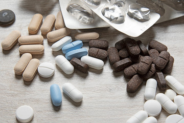 Close-up of pills lying on the table. Medical background from pills of different shapes and colors.
