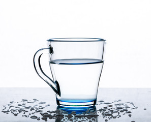 Clear, transparent water in a glass Cup on a table on a white background.