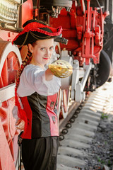 beautiful girl in a steampunk suit on a background of an old train