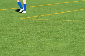 Obraz premium Youth soccer player feet on empty green grass football practice ground