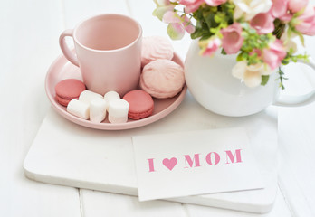 Mother's Day Greeting Card. Romantic breakfast. Happy mothers day frame background. Tea set with flowers and sweet. Spring card template. Happy Birthday or Valentine. Women's Day. Copy space.