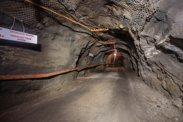 Underground gold mine shaft tunnel drift with rails and light
