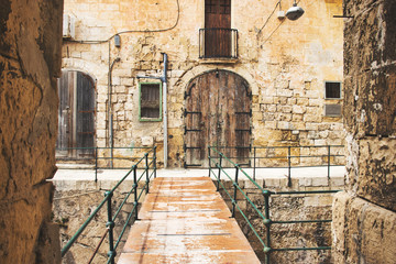 Fototapeta na wymiar Street in old mediterranean town (Valletta, Malta).old bridge to house