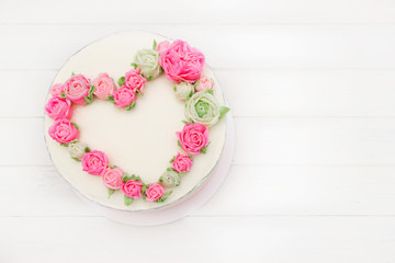 Cake with heart of pink  creame  roses, white background, wooden board. Concept for Wedding , St. Valentine's Day, Mother's Day, Birthday Cake