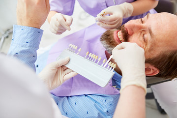Man as a patient adjusting the tooth color
