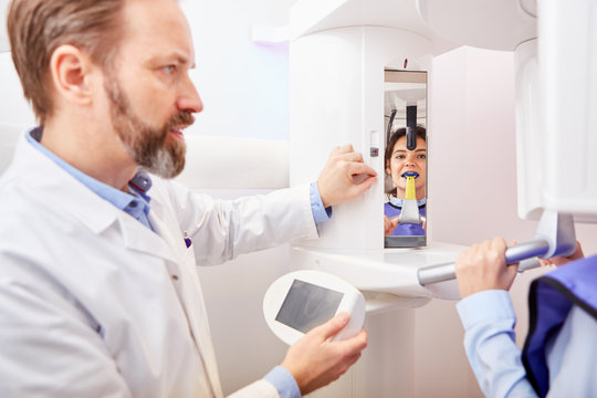 Dentist operates x-ray device in radiology