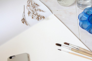Brushes for painting and blank white paper sheet of sketchbook.