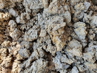 Close-up of a small, grayish-yellow clay pile, which is the soil that the contractor dug out from the construction area.
