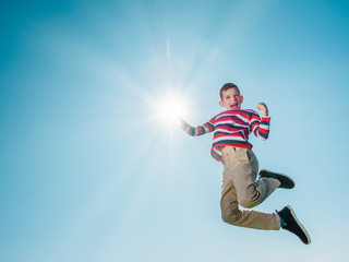 Fototapeta na wymiar young boy jumping high and reaching the sun