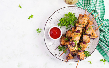 Grilled chicken kebab with red onions on a light table. Grilled meat skewers, shish kebab on light...