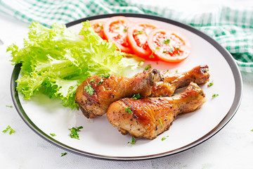 Grilled chicken legs with spices and fresh vegetables. Baked drumsticks.