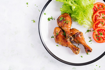 Grilled chicken legs with spices and fresh vegetables. Baked drumsticks. Top view, flat lay