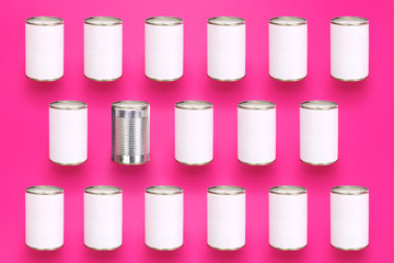 Tin cans with copy space in a diagonal pattern on a pink colorful background