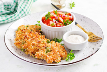 Homemade grilled chicken with green peas patties on a plate with tomatoes salad. Chicken cutlets.
