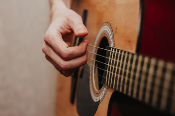 Fototapeta premium The guy is playing the guitar. Close plan