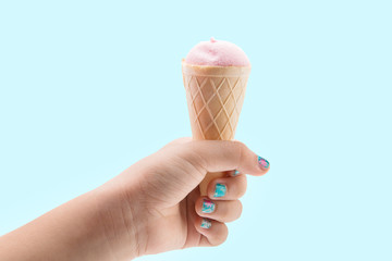Ice cream candy in the hand on the blue background
