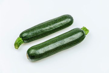 Two fresh whole zucchini isolated on white background