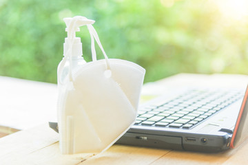 Laptop computer with N95 mask and alcohol gel necessary item in corona virus critical time