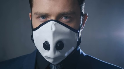 Close-up portrait of businessman in suit wearing medical mask during coronavirus covid-19 epidemic. - Powered by Adobe
