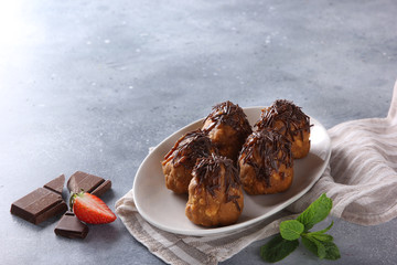 Dessert. Cookies with chocolate on a white plate. Anthill. Chocolate, strawberry, mint on a light grey background. Background image, copy space