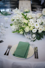 wedding table setting with flowers and green 
napkins