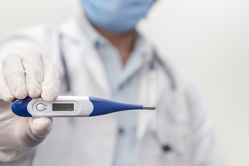 Male doctor holding a digital thermometer