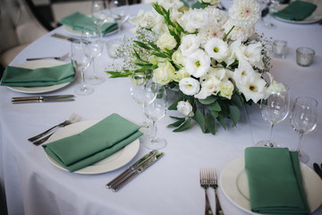 wedding table setting with flowers and green 
napkins