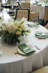 wedding table setting with green elements and flowers
