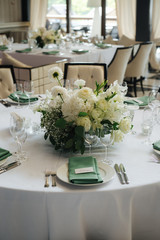 wedding table setting with green elements and flowers