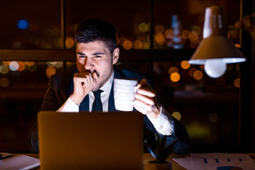 Business Man Yawning Working On Laptop Having Coffee In Office