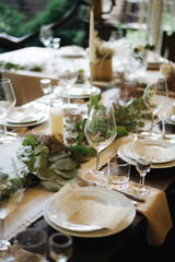 table set for a wedding reception; table in restaurant; wedding table setting; long table with decoration; table set for a dinner