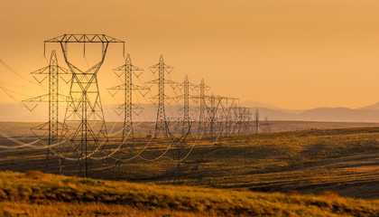 Electrical power lines through a rural landscape at sunset, USA