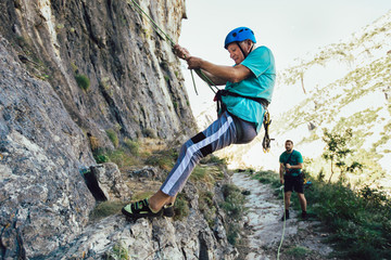Obraz premium Senior man with a rope climbing on the rock.