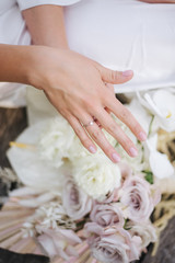 bride hands with rings with background of flowers