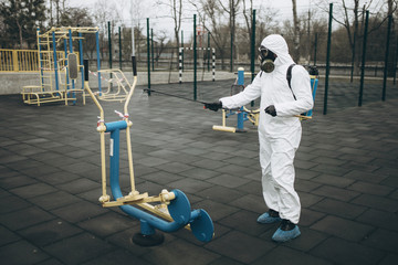 Cleaning and Disinfection on the playground in the sity complex amid the coronavirus epidemic Teams for disinfection efforts Infection prevention and control of epidemic Protective suit and mask