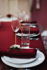 romantic dinner table setting; glasses on the festive table; glasses on a red tablecloth