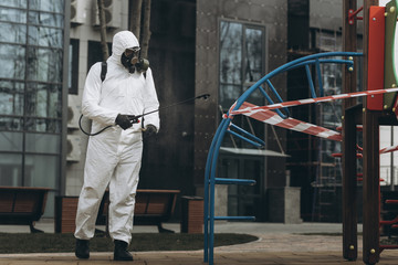 Cleaning and Disinfection on the playground in the sity complex amid the coronavirus epidemic Teams for disinfection efforts Infection prevention and control of epidemic Protective suit and mask