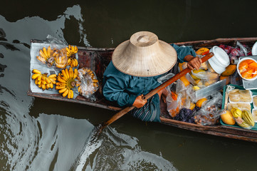 Woman on boat in Damnoen Saduak Floating Market in Bangkok Thainland 