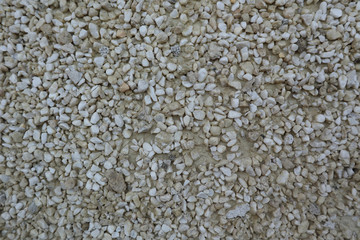 Background made of small gray pebbles in the cement
