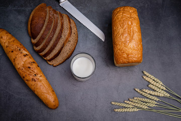 Composition with a variety of bakery products on a wooden table. Glass of milk.