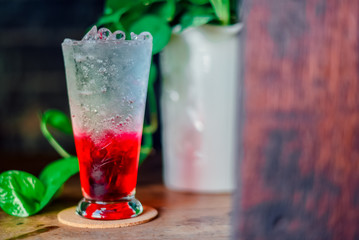 red juice water whit soda in glass on wood table at cafe. Summer  drink